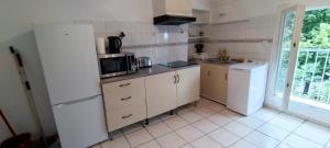 吕内尔Appartement 45 m² proche du centre ville的厨房配有冰箱和微波炉。