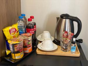 曼谷Casa Luxe Hotel and Resident的柜台,配有咖啡壶和一些食物及饮料