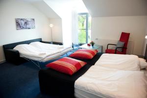 锡尔克堡维特斯胡斯会议中心酒店的一间卧室配有两张带红色枕头的床。