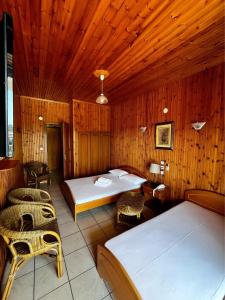 帕拉利亚潘塔利莫诺斯巴罗吉亚尼斯酒店的一间卧室配有两张床和椅子。