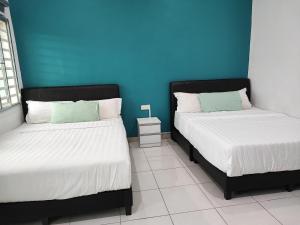 金马仑高原W21 atGoldenHills NightMarket WiFi 4R的两张睡床彼此相邻,位于一个房间里