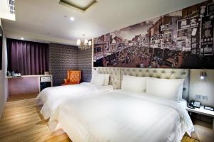 台南富驿时尚酒店的酒店客房设有两张床,墙上挂有绘画作品