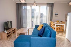 弗瓦迪斯瓦沃沃Apartamenty Jachtowa的客厅配有蓝色的沙发和电视