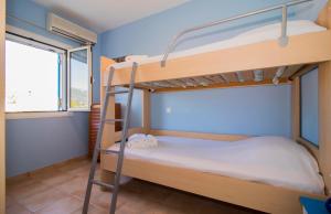 莫奈姆瓦夏Laconian Collection ''Le Bleu Infini''的一间卧室设有两张双层床和一扇窗户。