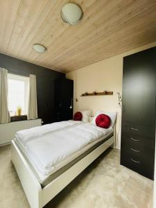腓特烈港aday - Private room - Frederikshavn Center的卧室配有带红色枕头的大型白色床