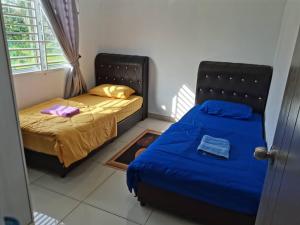 大港Abah StayCation的一间卧室设有两张床和窗户。