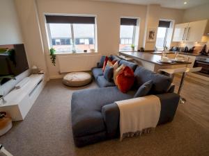 诺丁汉Pass the Keys Stunning 1 bedroom Penthouse in Nottm City Centre的一间带蓝色沙发的客厅和一间厨房