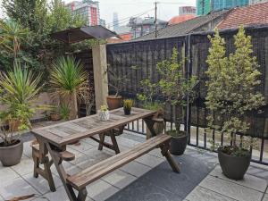 吉隆坡Cheras-Miharja Homestay @Sunway Velocity的木桌和长凳,位于种有植物的庭院