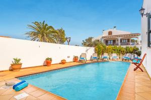 桑坦德利亚湾Villa Mafel by Villa Plus的一个带椅子的游泳池以及一座房子
