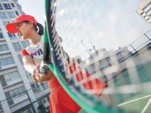 雅加达FX苏迪曼哈里斯套房酒店的一名在球场上打网球的女人