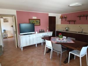 NasoCasa Vacanze Nino Petrelli的一间带桌子和电视的厨房以及一间用餐室