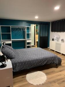Poyannela petite Poyannaise的一间卧室设有一张大床和蓝色的墙壁