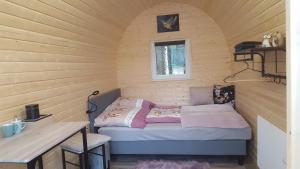 诺尔德霍尔茨Glamping Pod的小房间,木墙里设有一张床