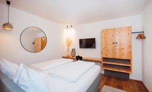 施塔姆斯Hotel Gasthof Hirschentenne的卧室配有一张白色大床和镜子