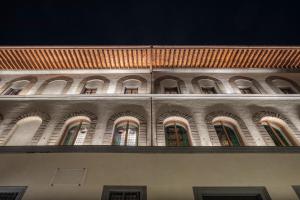 佛罗伦萨Palazzo Portinari Salviati Residenza D'Epoca的建筑的一侧有拱门