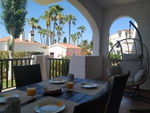 卡拉恩波特Apartamento recién reformado en Cala en Porter的棕榈树阳台的桌子上摆放着食物和饮料