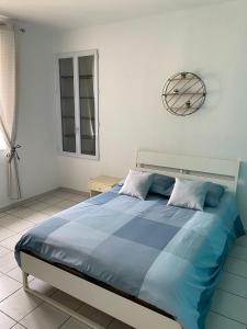 奥朗日APPARTEMENT SPACIEUX的卧室配有一张大蓝色床,墙上挂着时钟