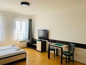 巴甫洛夫Dovolená bez starostí - Apartmány u Venuše的客房设有1张床、1张桌子和1台电视。
