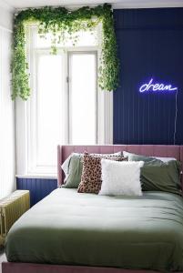Saint-SiméonAuberge Du Bon Yeu的卧室配有一张墙上 ⁇ 虹灯标牌的床