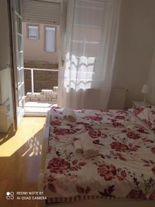 凯斯特海伊Villa Vanília的一间卧室配有一张带花卉床罩的床和窗户。