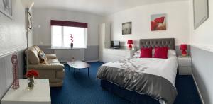 布莱克浦戴尔城堡假日公寓的一间卧室配有一张床、一张沙发和一把椅子