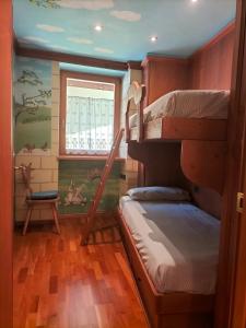 安达洛Il nido incantato的客房设有两张双层床和一扇窗户。