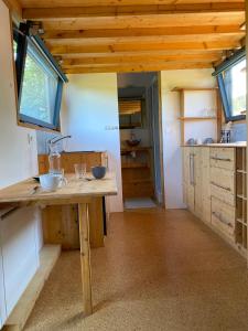 Prattiny house du poulloguer的厨房配有木制橱柜和木桌。