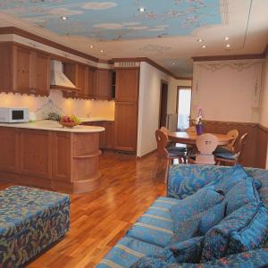安达洛Il nido incantato的一间带蓝色沙发的客厅和一间厨房