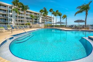 圣彼得堡Bahia Vista 8-314, 2 Bedroom, Heated Pool, Spa, WiFi, Sleeps 6的一座种植了棕榈树的大型蓝色游泳池和一座建筑