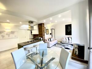 特罗佩阿Mottola Apartment的厨房以及带玻璃桌和椅子的客厅。