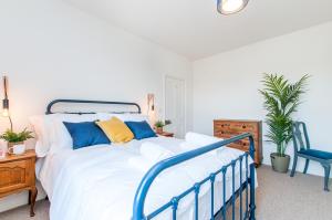 马盖特Queen Palm Apartment - Margate - 3 mins walk to beach的一间卧室配有蓝色和黄色枕头的床