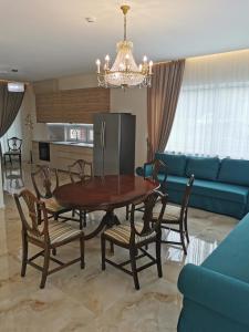 克莱佩达Beach Lounge Luxory Apartments的一间带桌椅和蓝色沙发的用餐室