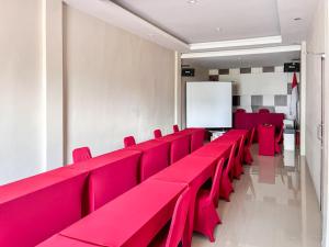 特尔纳特岛RedDoorz Plus @ Grand Tabona Hotel Ternate的一间白色板房里的一排红色椅子
