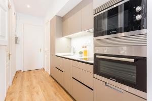 巴塞罗那Cozy Apartment close to Passeig de Gracia的厨房配有不锈钢用具,铺有木地板
