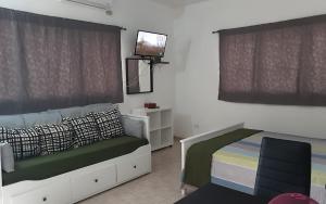 里奥圣胡安Villa Colonial suite n 3 familiar的卧室配有一张床,墙上配有电视。