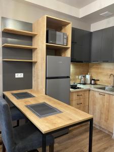 萨克德佐尔镇Kechi Apart Hotel的厨房配有木桌和冰箱。