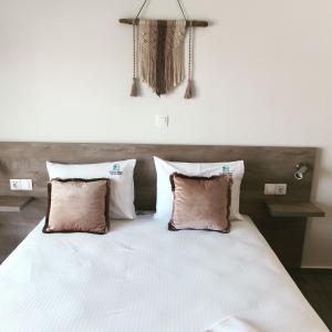 阿莫利亚尼岛elenamou seaview rooms的卧室配有一张带三个枕头的大型白色床