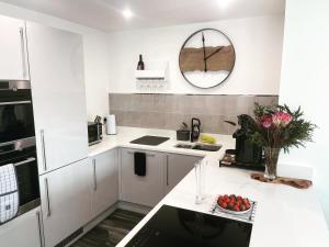 梅奈布里奇Salisbury Suite - Modern 2 bedroom flat with parking in Menai Bridge的白色的厨房,配有带一碗水果的柜台