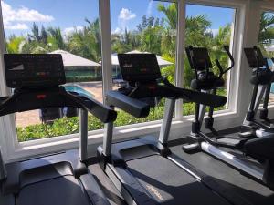 自由港市海豚湾公寓式酒店的窗户前有三个跑步机的健身房