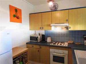 帕皮提TAHITI - Studio Te Maraamu的厨房配有木制橱柜和炉灶烤箱。