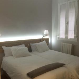 马德里迪斯马德里旅馆的卧室配有一张大白色床和大枕头