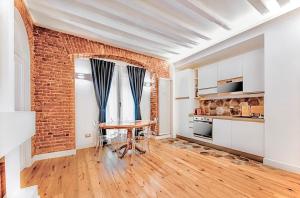 米兰Luxury Apartment in Milan Center的厨房配有桌子和砖墙