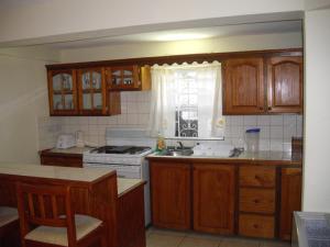 圣乔治杰瑞东公寓的厨房配有木制橱柜和炉灶烤箱。