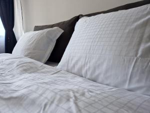 布尔加斯Apartment Enya的一张带白色床单和枕头的未铺好的床