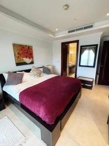 多哈Luxury 2 bedroom Apt in The Pearl with Marina view的一间卧室配有一张大床和紫色毯子
