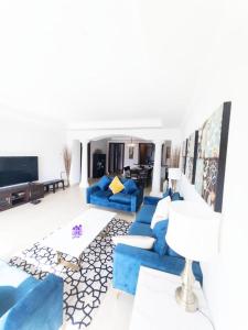 多哈Luxury 2 bedroom Apt in The Pearl with Marina view的客厅配有蓝色的沙发和电视