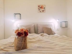 杜基拉特Apartman Aria的一张白色的床,上面有一篮鲜花