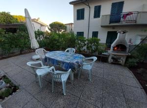 卡斯蒂利翁切洛Appartamento Castiglioncello 600 mt dal mare的带壁炉的庭院配有桌椅