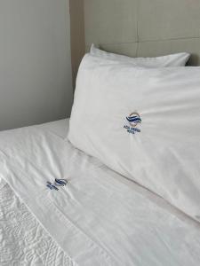 马萨特兰AZUL ARENA Hotel Boutique的一张带白色床单和标志的床