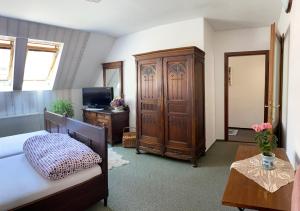 然贝尔克Penzion Country Club的一间卧室配有一张床、一个橱柜和一台电视